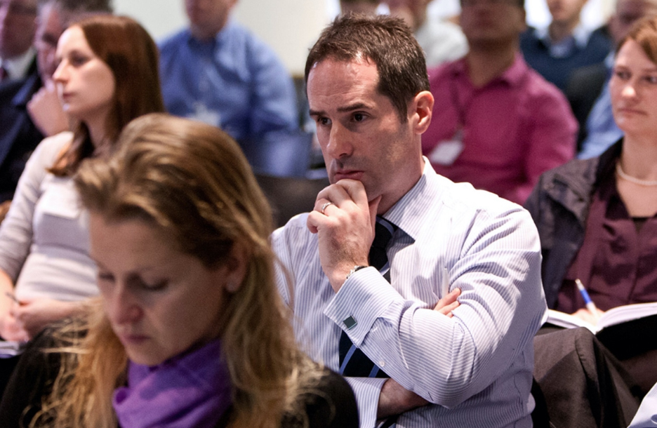 Man at conference with hand on chin concentrating